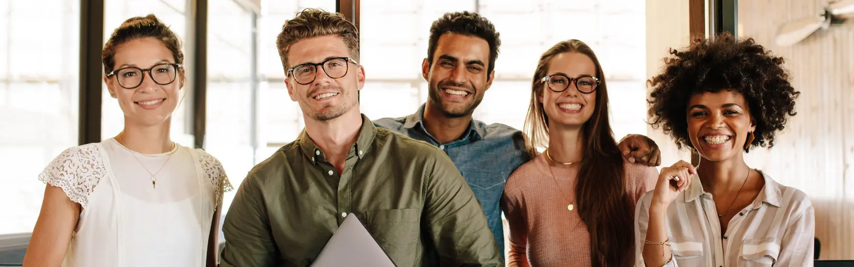 Portrait of successful creative business team looking at camera and smiling. Diverse business people standing together at startup.