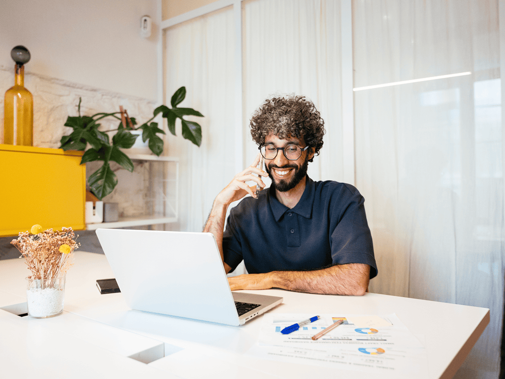 Man smiling while talking on the phone.