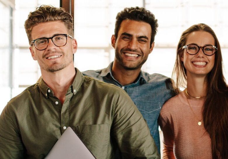 Portrait of successful creative business team looking at camera and smiling. Diverse business people standing together at startup.